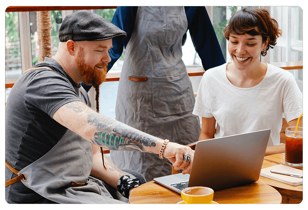 coffee shop owners reviewing data and performance on laptop